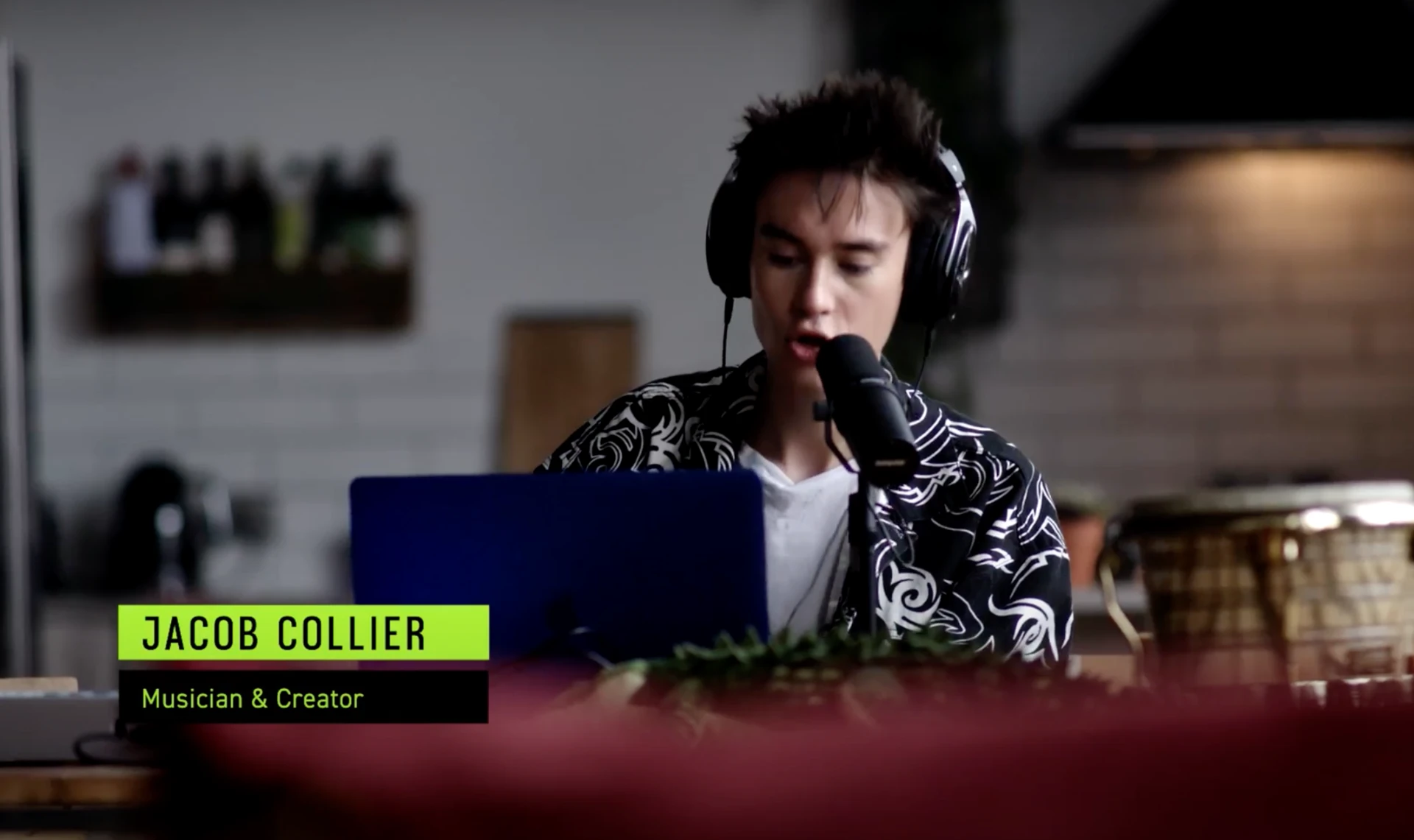 Jacob Collier singing into a microphone while wearing headphones during the Shure AONIC FREE campaign shoot