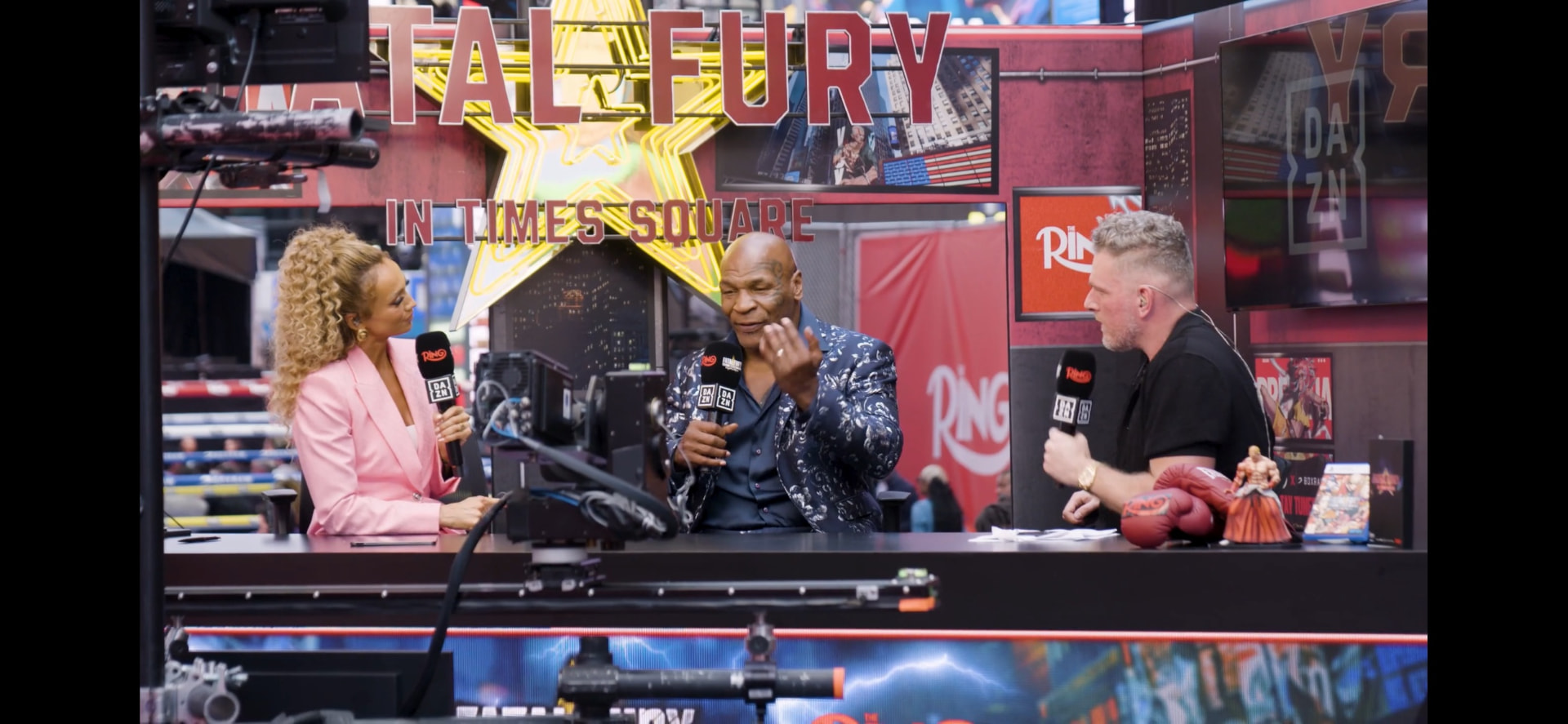 Live broadcast desk with presenters and Mike Tyson at the Fatal Fury event in Times Square, New York