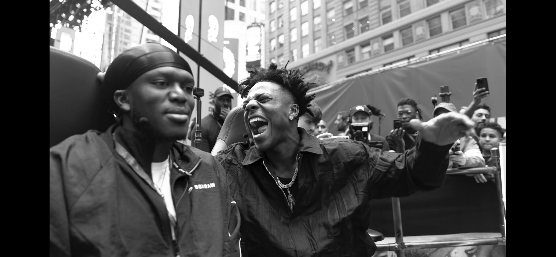 KSI and IShowSpeed on an open-top bus surrounded by fans and cameras in New York